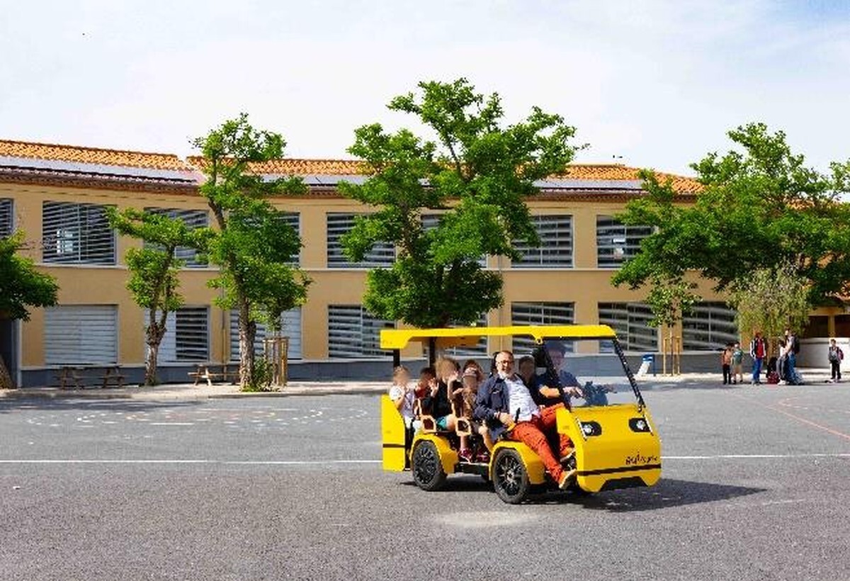 Un groupe pose devant le OuiCycle, dans la cour d'une école