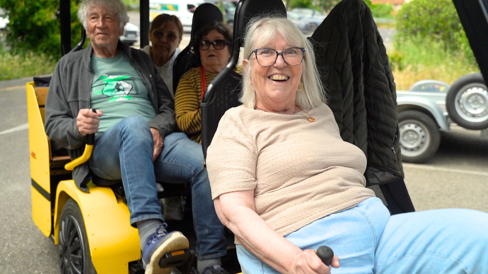 Passagers souriants à bord du OuiCycle, dont une résidente rieuse au premier plan.
